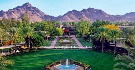 A garden with fountains and a view of mountains.